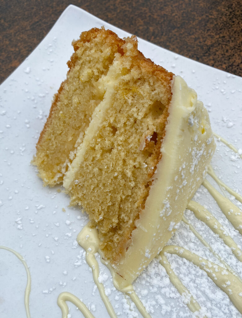 slice of golden lemon curd cake with buttercream frosting