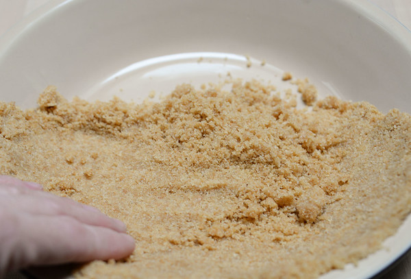 Forming the graham cracker crust. 