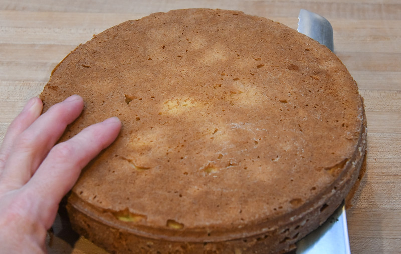 Holding the cake with my left hand, I slice the cake horizontally using a serrated knife. 